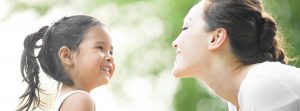 Mother and daughter facing each other and smiling